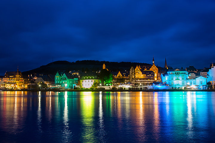 Das Bild zeigt die bunt beleuchtetet Skyline der Moselstadt Traben-Trarbach bei Nacht.