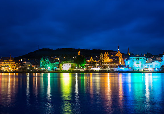 Das Bild zeigt die bunt beleuchtetet Skyline der Moselstadt Traben-Trarbach bei Nacht.